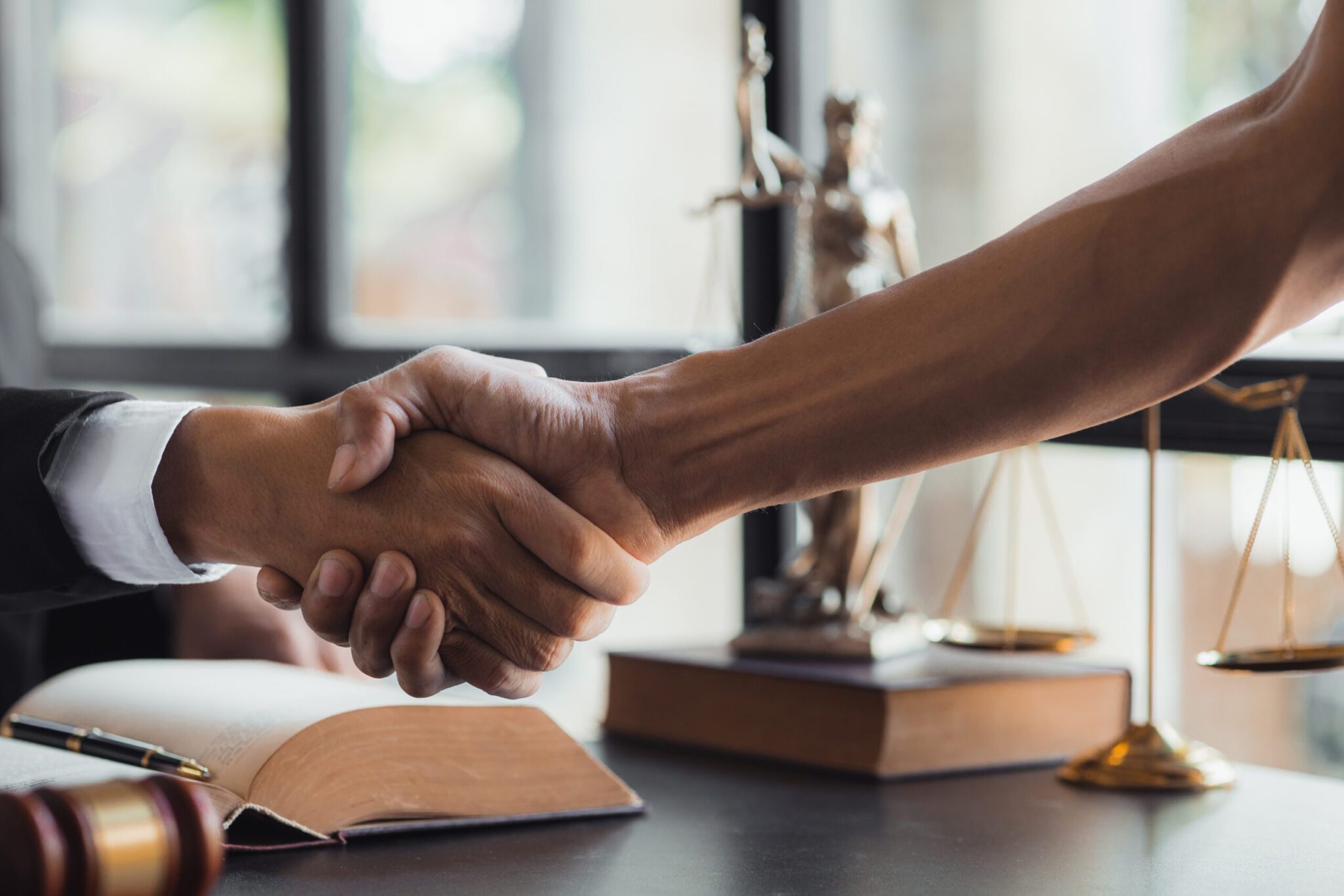 Lawyer and client shake hands, after winning a lawsuit where a l Lawyer and client shake hands, after winning a lawsuit where a lawyer hired by a client in a fraud case and proceeding in a fair and correct manner, the client wins the case. Fraud litigation concept.